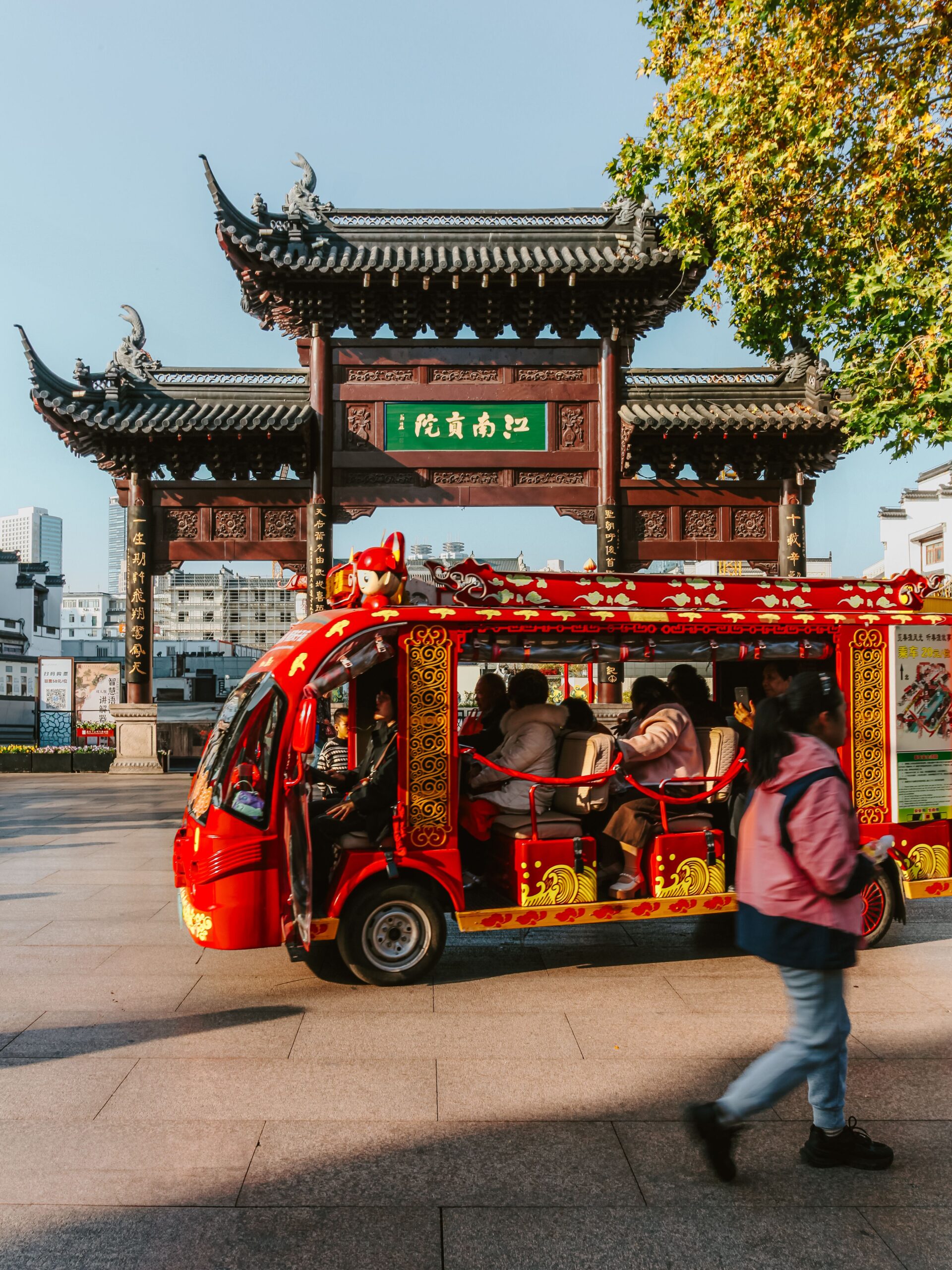 camioneta roja pequeña con personas dentro de ella dando tour por la ciudad de china