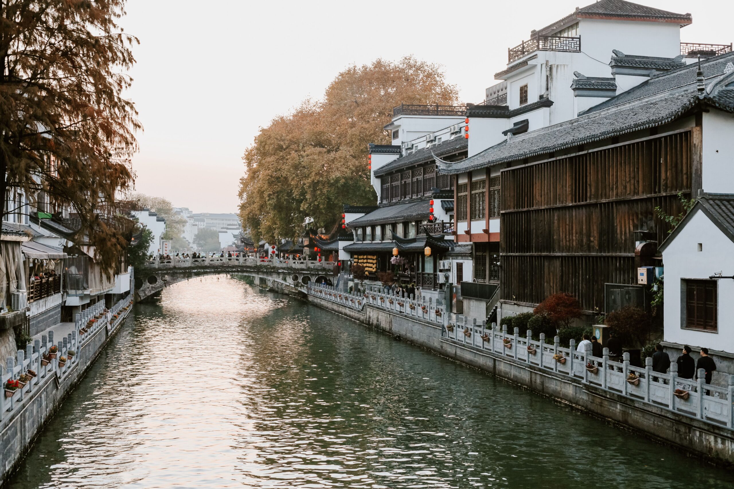 una ciudad asiatica sobre un ruido, de lado derecho hay edficios tipicos en medio hay un puente que conecta con el otro lado de la ciudad